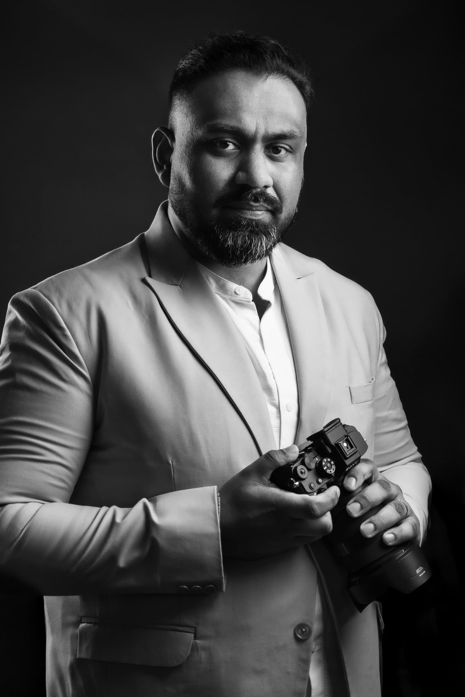 Austin Vows founder holding a camera, studio portrait